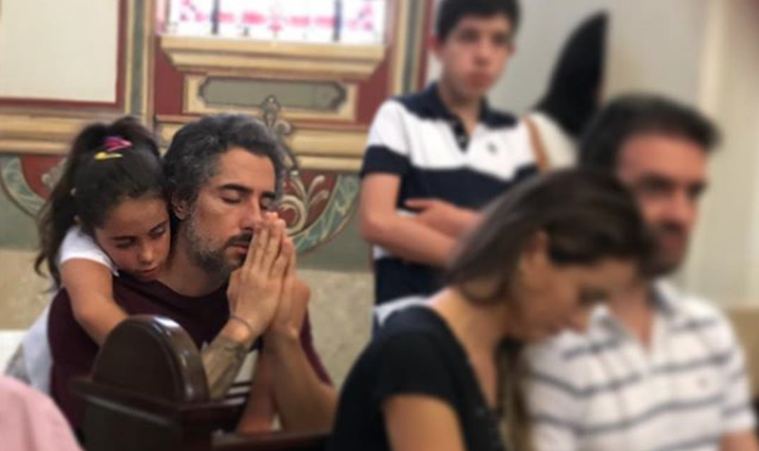 Apresentador Marcos Mion em oração na companhia de sua filha, Donatella