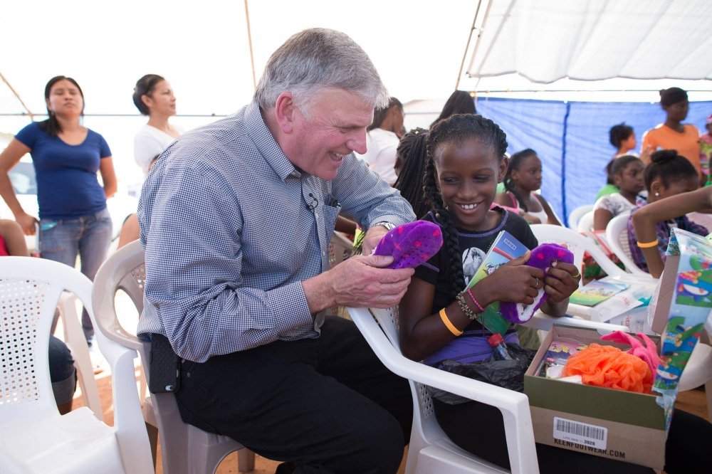 Franklin Graham entrega uma caixa de sapatos cheia de presentes da Operação Natal Infantil, em 2015