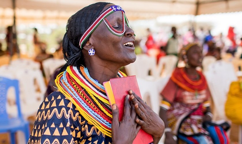 Mulher Rendille coloca Novo Testamento traduzido para seu idioma perto do coração. (Foto: Esther Havens)