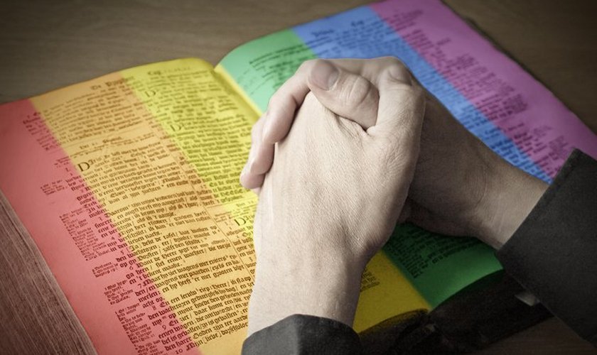 Mãos sobre uma Bíblia colorida (imagem ilustrativa)