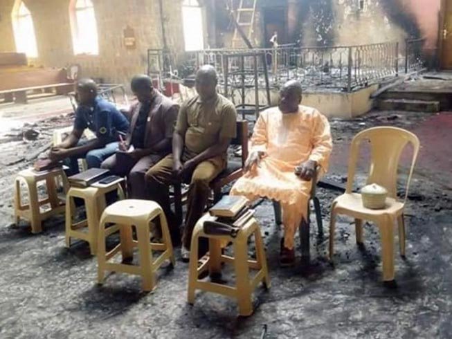 Os anciãos da igreja nigeriana realizam o culto de domingo em meio às cinzas de sua igreja (Foto: Reprodução / Barnabas)