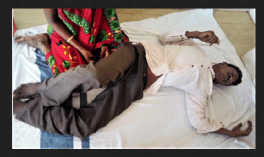 Kama Sodi diante de sua esposa, depois de aldeões animistas o espancarem no estado de Odisha, na Índia.