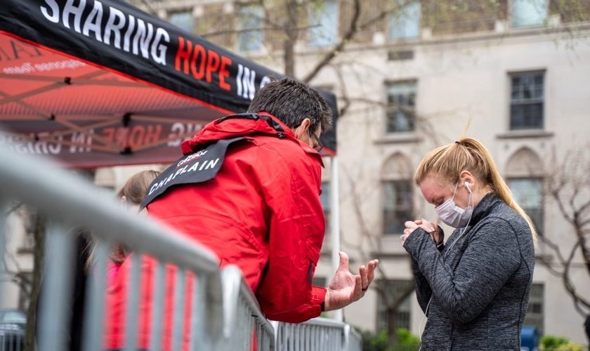 Capelão Charlie Clark ora pela moradora de Nova York, Jennifer Armitage, em frente à tenda de oração. (Foto: Billy Graham Evangelistic Association)