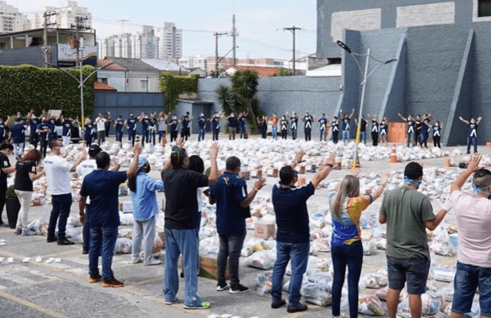 Membros da Igreja Renascer em Cristo oram antes da distribuição dos alimentos.