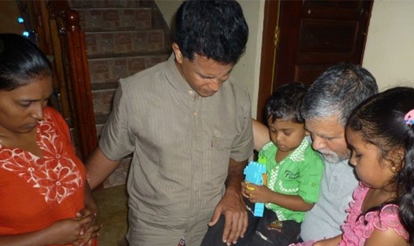 Pastor ora com cristãos no Sri Lanka. (Foto: Reprodução / Barnabas Fund)