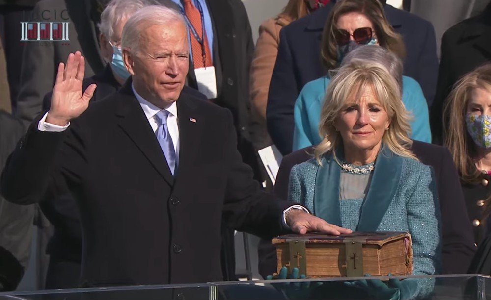 Joe Biden durante juramento na sua posse com a mão em uma Bíblia.