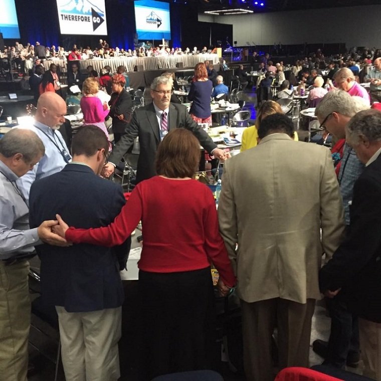 Delegados oram antes de uma sessão plenária na Conferência Geral da Igreja Metodista Unida 2016 em Portland, Oregon. (Foto: Conferência Geral do Facebook / Metodista Unida)