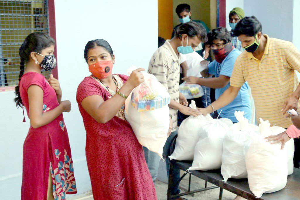 Pessoas na Índia recebem alimentos