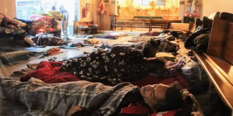 Moradores de rua abrigados em uma igreja