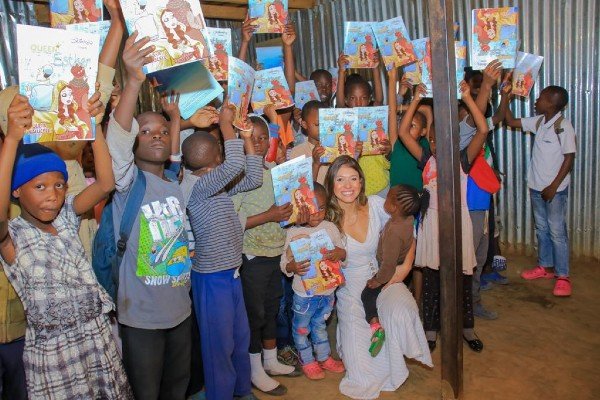 Júlia Malucelli com crianças segurando o livro 
