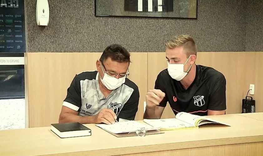 O jogador Klaus ensinando Seu Orlando a ler. (Foto: Reprodução)