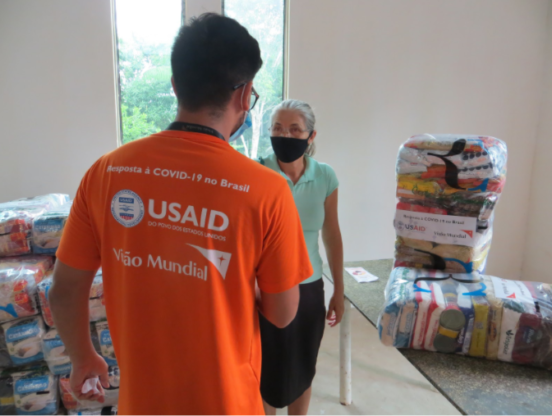 Equipe da Visão Mundial durante distribuição de cestas de alimentos