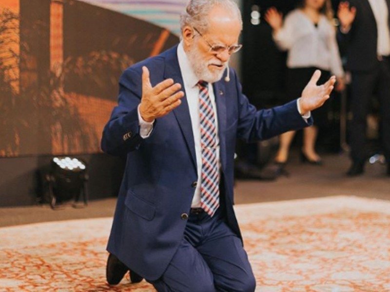 Pastor Márcio Valadão, de joelhos, orando durante culto na Igreja Batista da Lagoinha