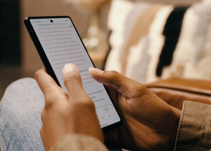 Pessoas na América Latina engajadas na leitura da Bíblia através de seus dispositivos móveis, destacando o uso de plataformas digitais.