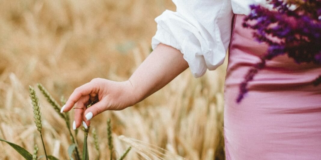 Mulher com expressão serena e esperançosa, segurando um objeto que representa uma promessa ou bênção.