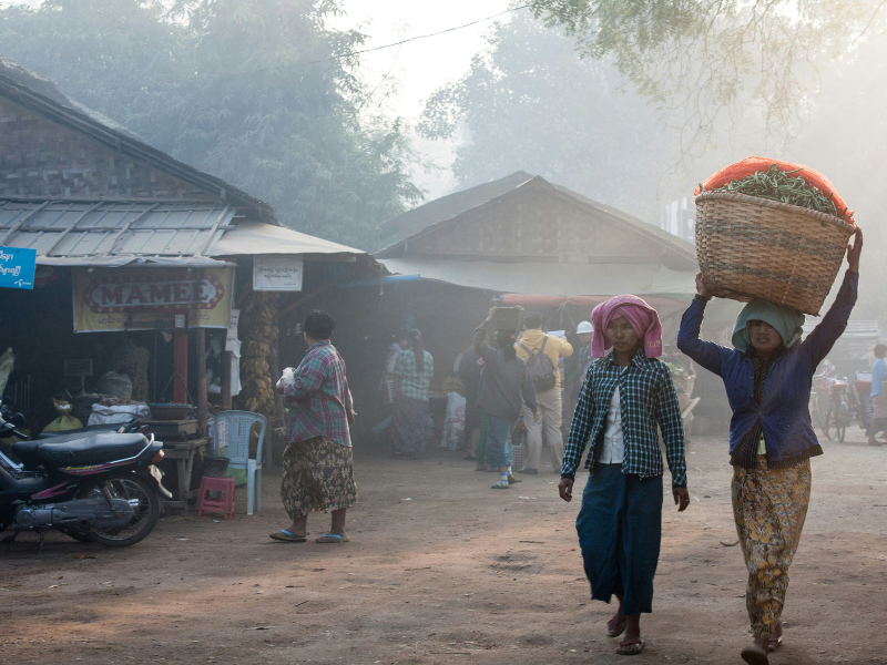 Civis birmaneses em meio a destroços após ataque aéreo, expressando desespero.