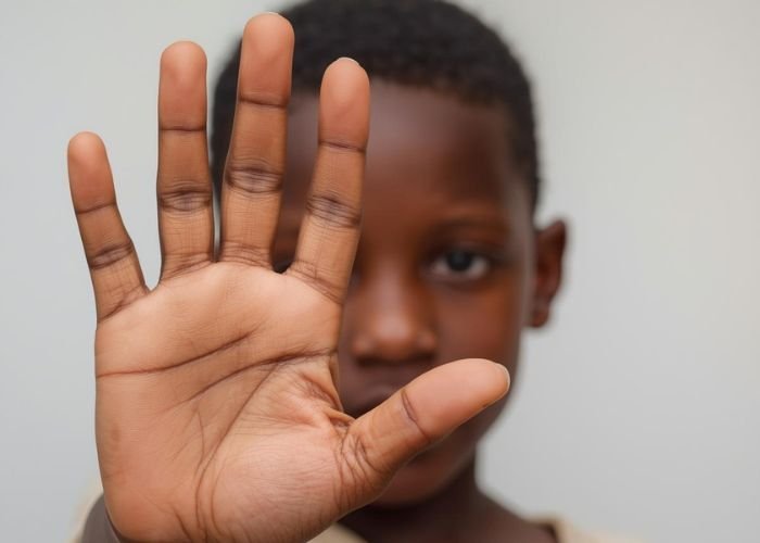Criança em sala de aula no Norte da África com expressão triste, refletindo sobre sua situação escolar.