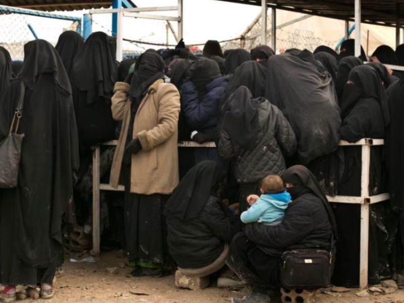 Mulheres e crianças escapando de um campo de refugiados na Síria.