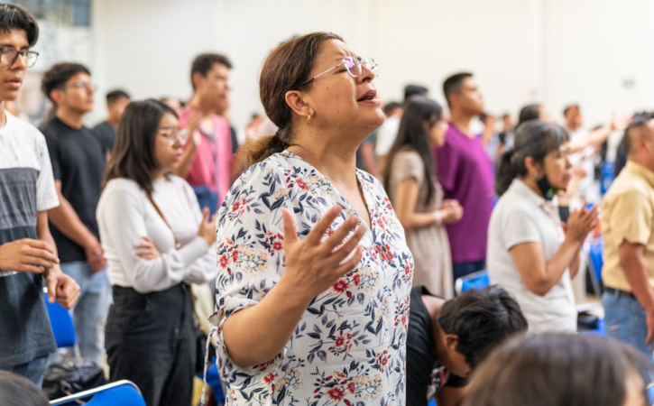 Mulheres de diversas idades e etnias em um culto religioso, demonstrando devoção e pertencimento.