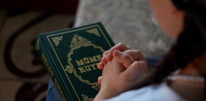 Menina na Ásia Central sentada em sala de aula com expressão pensativa