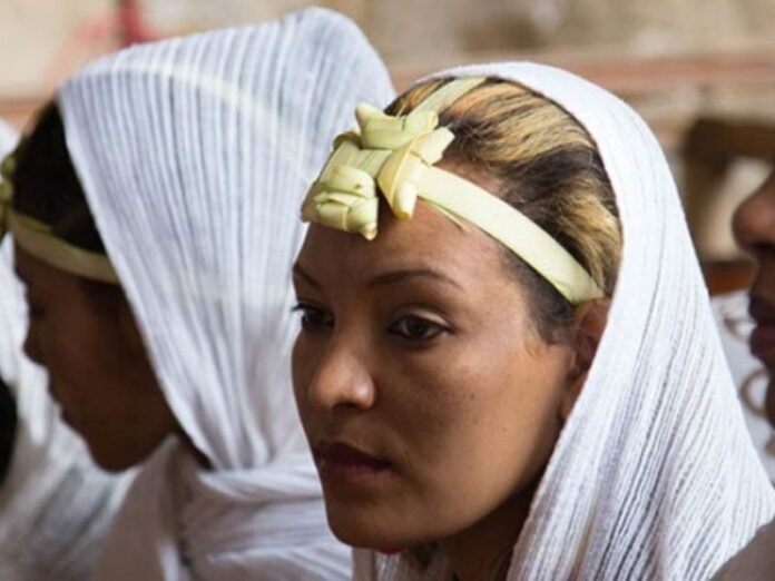 Preocupação e vulnerabilidade nas ruas do Cairo Mulheres coptas jovens caminhando em uma rua do Cairo com expressões de apreensão.