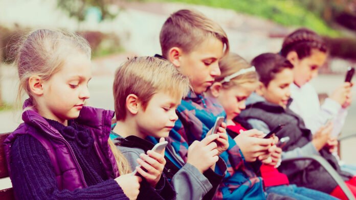 Aulas livres de smartphones: alunos guardam celulares em bolsas de travamento Alunos em sala de aula nos EUA guardando seus smartphones em bolsas com trava durante o período de aula.