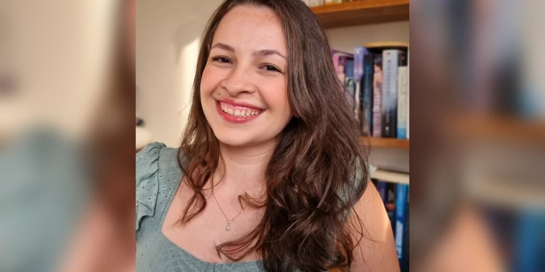 Jovem lendo um livro em um parque de Nova York sob a luz do sol da tarde