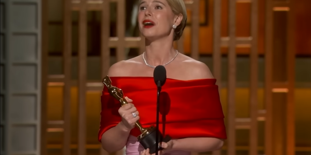 Jessie Buckley celebrando a vitória no Oscar com o troféu