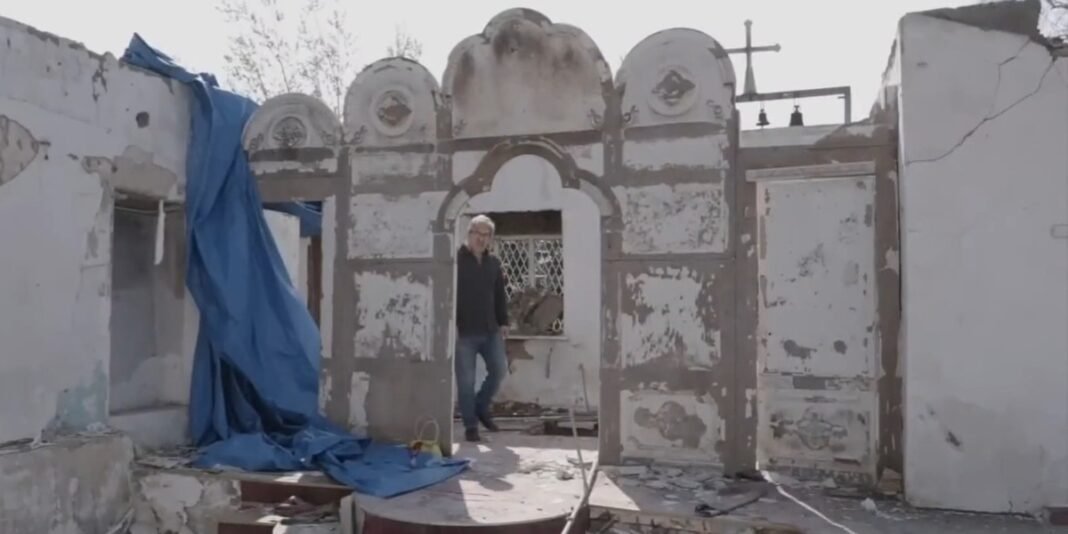 Templo religioso ucraniano parcialmente destruído pela guerra, com escombros e uma cruz de pé.