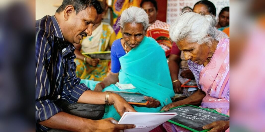 Adultos indianos aprendendo a ler e escrever com auxílio da Bíblia em sala de aula.