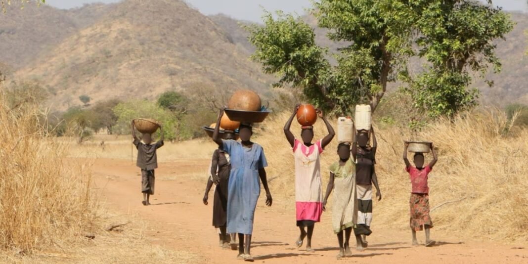 Refugiados sudaneses reunidos em um campo para ouvir uma leitura das escrituras em meio à guerra.