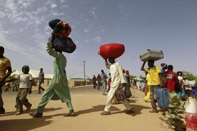 Família cristã em meio a escombros após ataque que destruiu sua casa