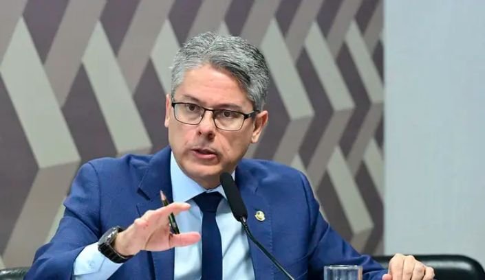 Sala de comissões no Senado Federal com mesa de autoridades e bandeira do Brasil.