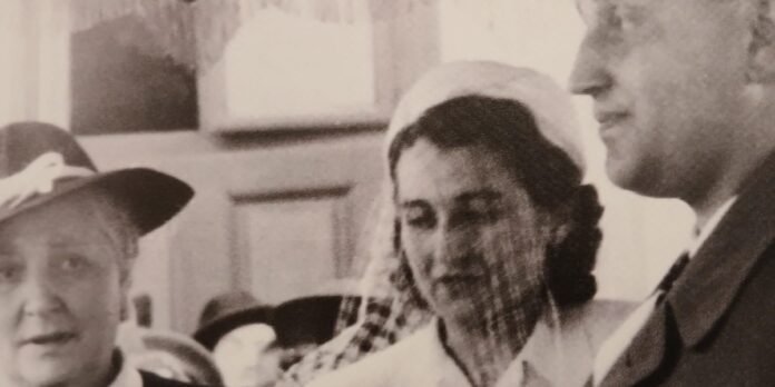 Mulheres em campo de concentração com um bebê recém-nascido, simbolizando esperança em meio ao horror.