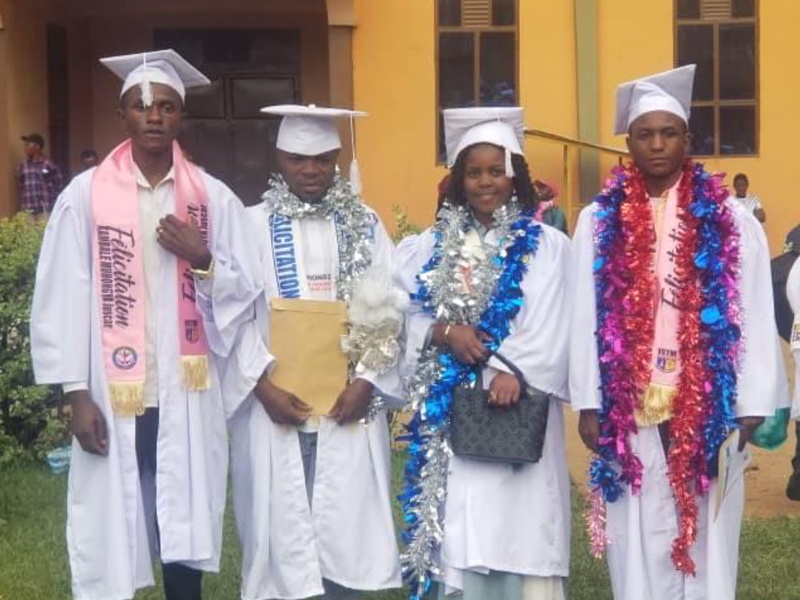Jovens sobreviventes de terrorismo celebram formatura universitária no Congo com diplomas em mãos.