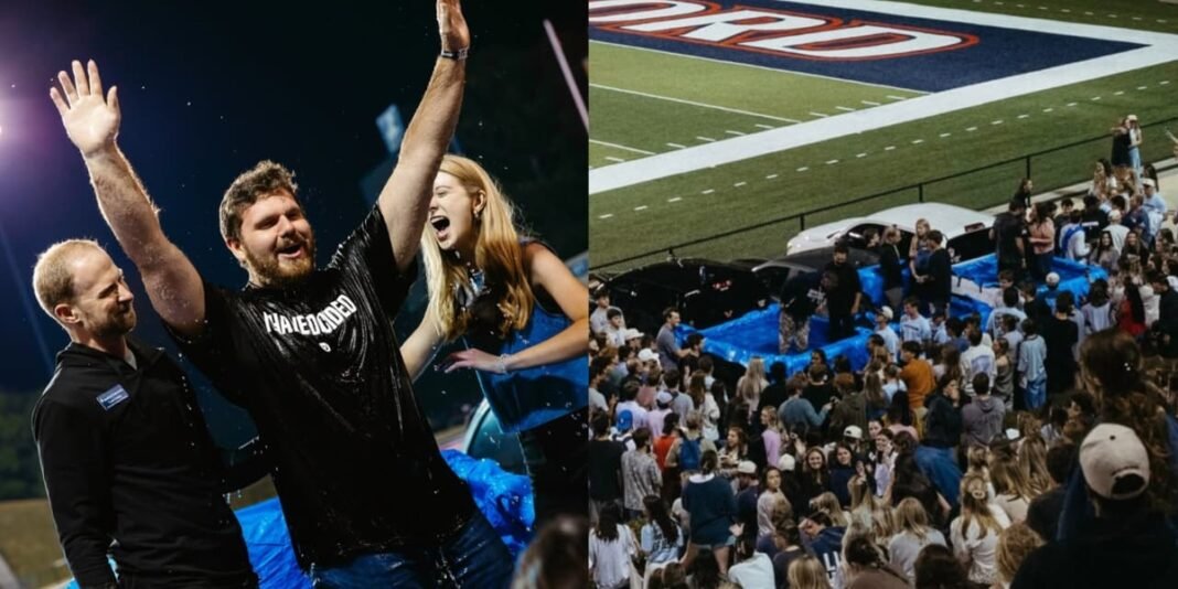 Jovens universitários sendo batizados em picapes no campo de futebol da Universidade de Samford, Alabama.