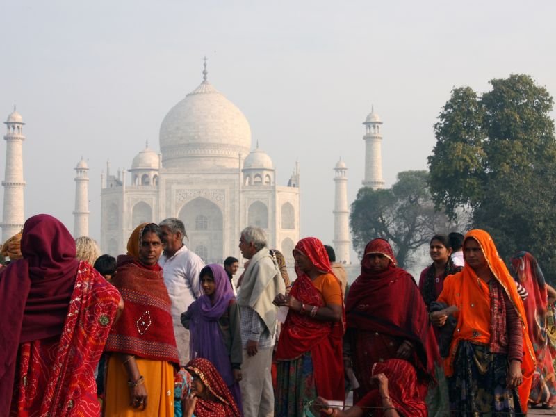 Mulher indiana de minoria religiosa participa do censo, com preocupação visível, enquanto um recenseador anota dados.