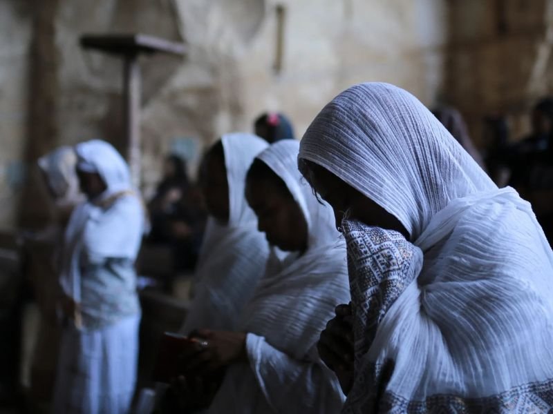 Pessoas orando secretamente em um cômodo escuro na Líbia