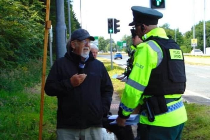 Pastor Clive Johnston pregando versículo bíblico perto de hospital