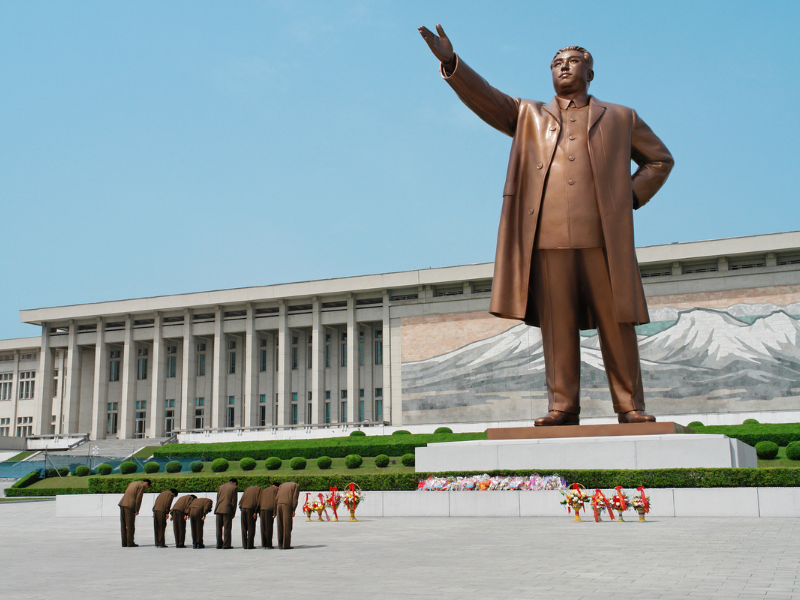 Edifício governamental em Pyongyang, Coreia do Norte, com bandeiras hasteadas.