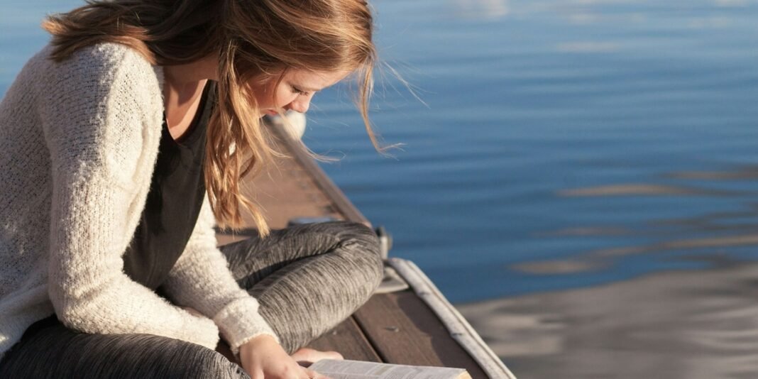 Escritora Mari Mendes refletindo sobre sua carreira e fé enquanto escreve.