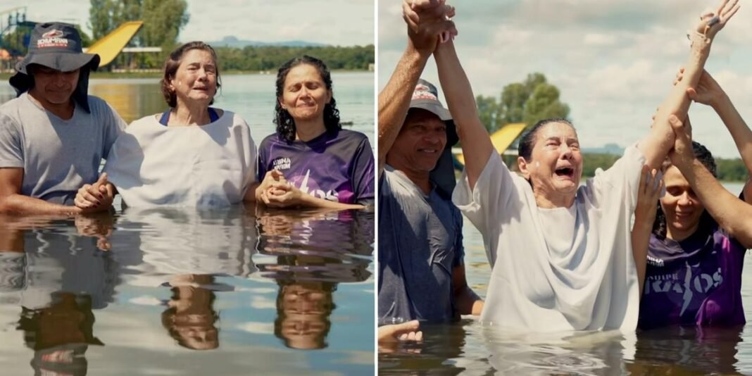 Idosa de 84 anos emocionada sendo batizada em rio.