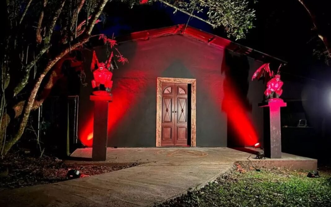 Fachada de templo religioso com iluminação noturna sutil e símbolo discreto.