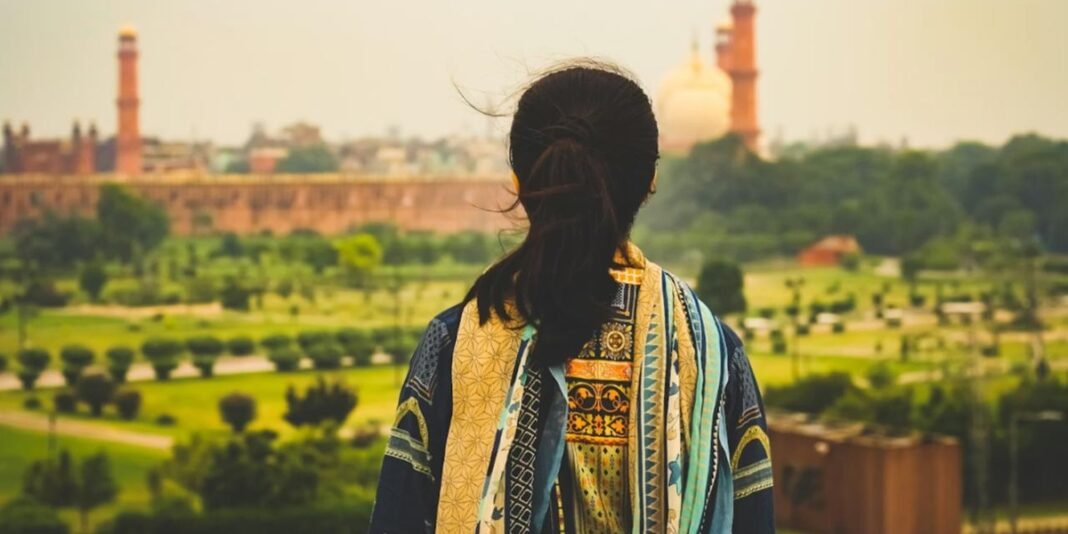 Mulher cristã em estado grave após violência no Paquistão, amparada por familiares em comunidade rural.