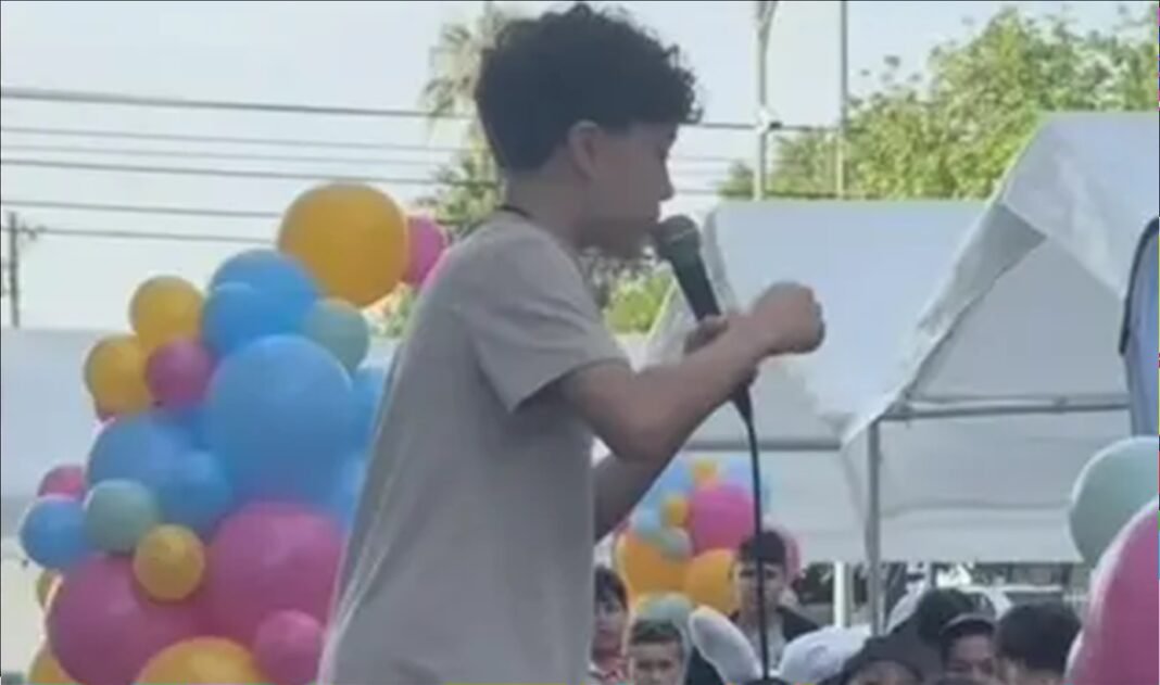 Menino de 11 anos pregando para uma multidão de crianças durante um evento de Páscoa