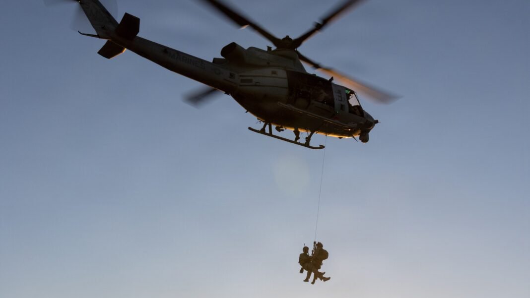 Helicóptero militar americano em missão de resgate sobre terreno desértico