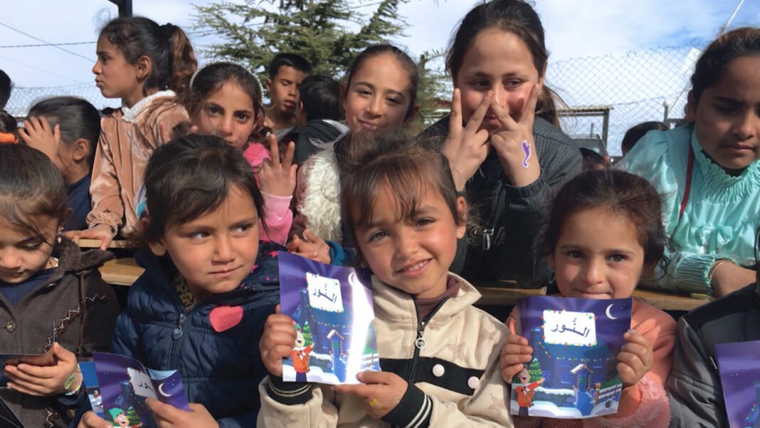 Voluntários da CEF distribuem ajuda e materiais religiosos para crianças em campo de refugiados no Oriente Médio, com esperança em meio à guerra.