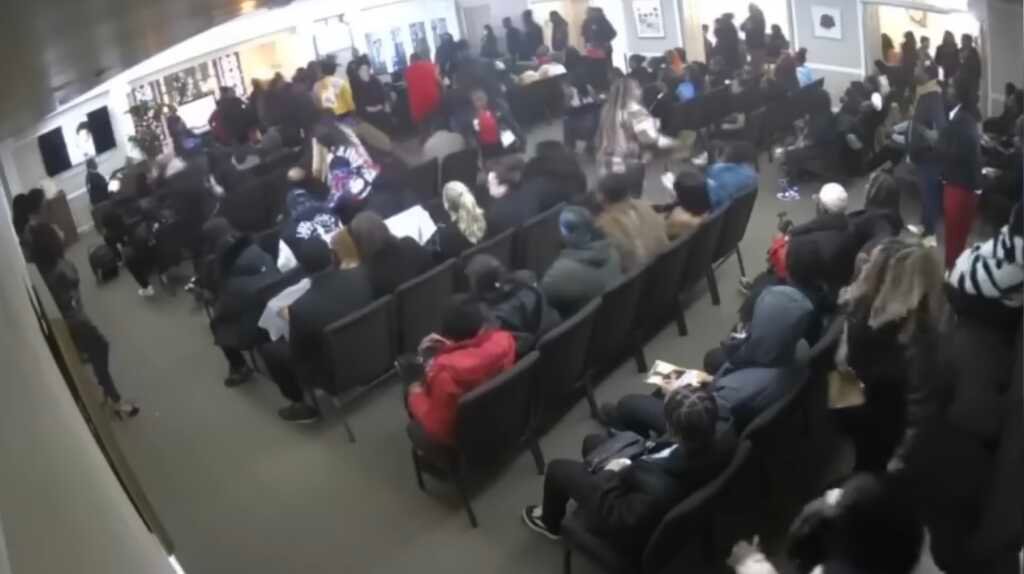 Pastor Darthanian Nichols em um funeral em Detroit, demonstrando calma enquanto um homem aponta uma arma.