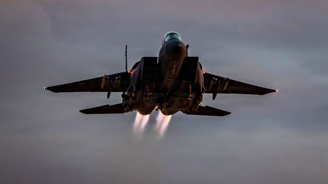 Avião de caça F-15E e helicóptero militar em operação de resgate no Irã ao amanhecer.