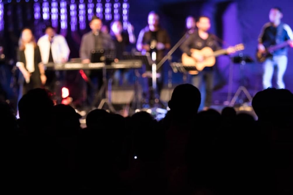 Líder de louvor com expressão pensativa em ambiente de igreja